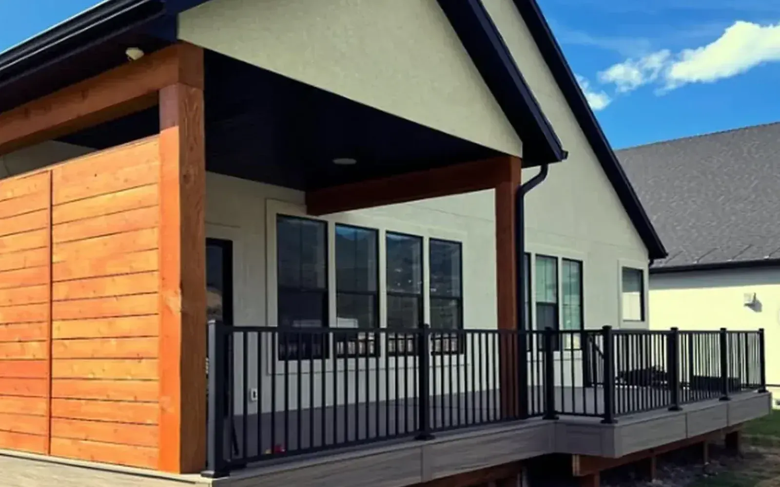 Frame Platinum deck project photo showing black railing, wood privacy detail, and covered porch